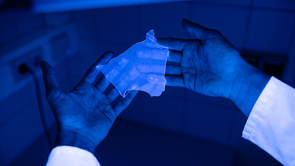Silicone synthesized at the HSZG, which is marked with a fluorescent dye, lies in two open hands.