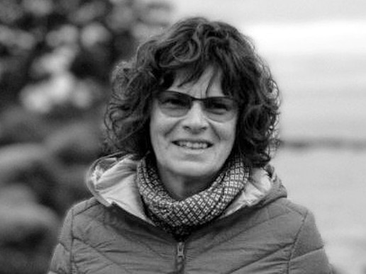 Julia Renger in natural surroundings smiles at the camera.