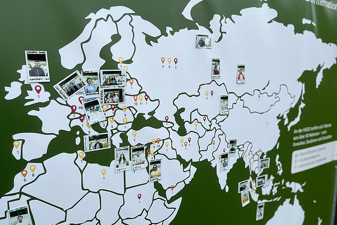 Polaroid photos are pinned to a world map.