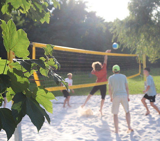 Students play volleyball at Lake Berzdorf.