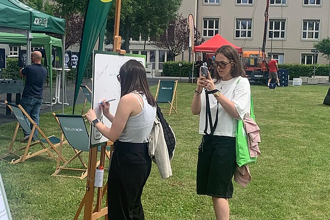Two students film the festival site with their cameras.