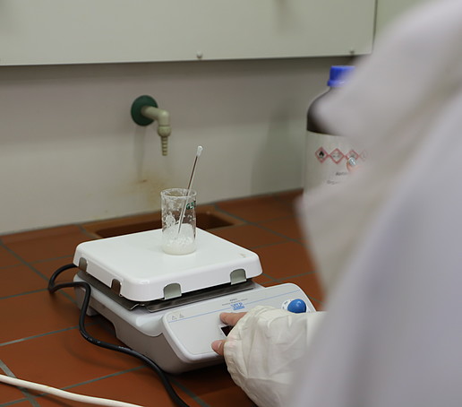 A glass dish is placed on a measuring plate under the extractor fan.