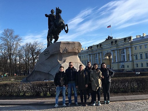 Studentinnen und Studenten bei einem Stadtrundgang vor einem Denkmal von Zar Peter dem Großen