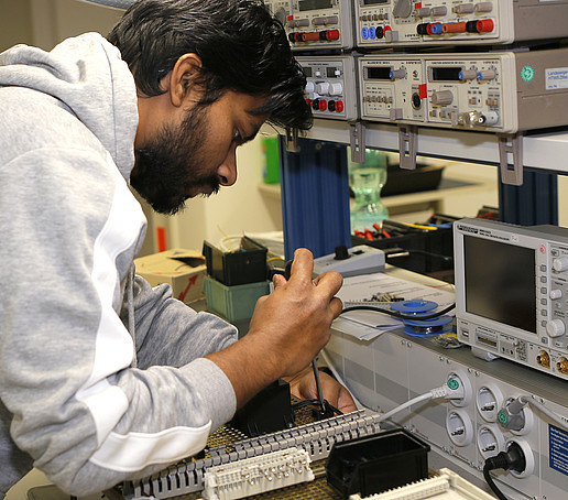 Ein Auszubildender arbeitet in der Lehrwerkstatt an einem Gerät.