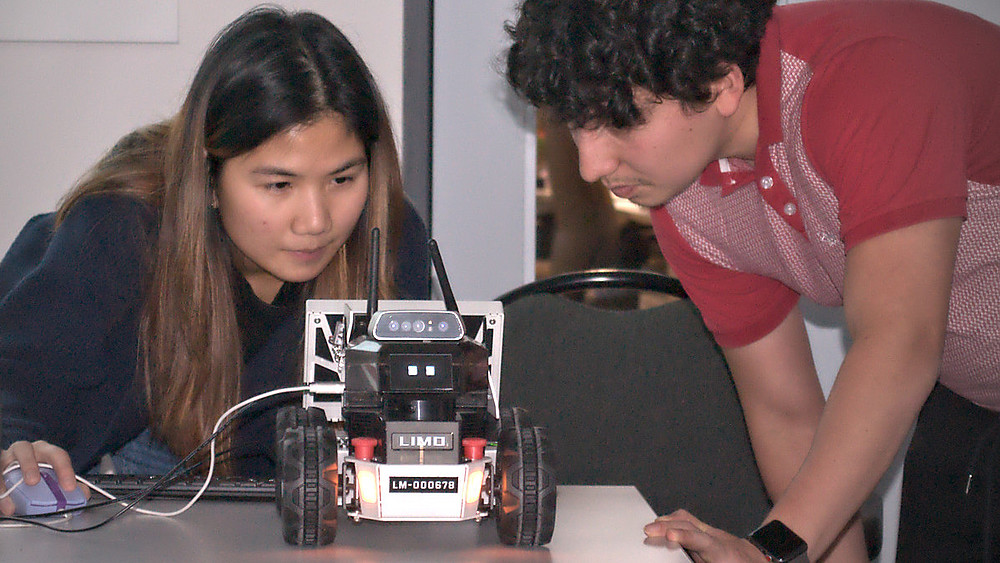 A Thai student demonstrates the autonomous functions of a model vehicle.