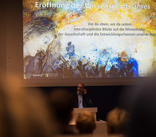 Professor Raj Kollmorgen stands at a lectern and gives a lecture.
