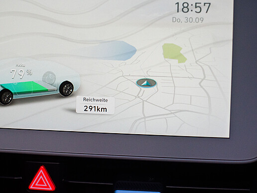 Auf einem digitalen Bildschirm ist eine digitale Landkarte mit einem digitalen Elektroauto zu sehen. Es wird die noch verfügbare Reichweite von 291 km angezeigt.