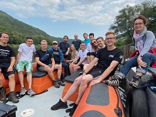 A group of students and members of the VDE HSG Zittau and the district association VDE Dresden are sitting in a powerboat on the Elbe.