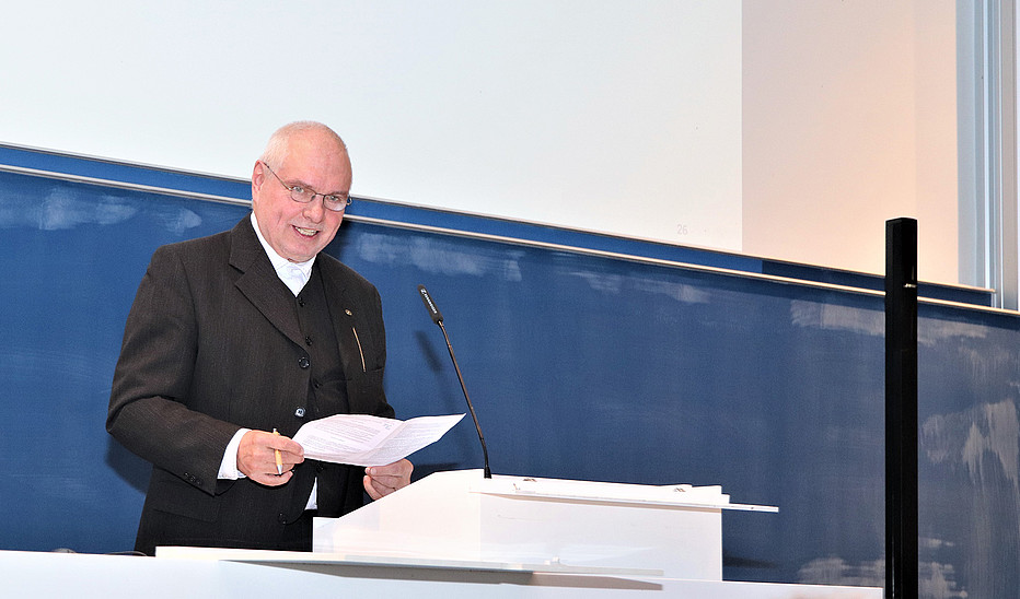 Foto: Christiane Matthieu Mann im schwarzen Jacket hält eine Rede