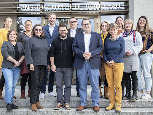Workshopteilnehmende stehen auf dem Treppenaufgang vor Haus Z eins.