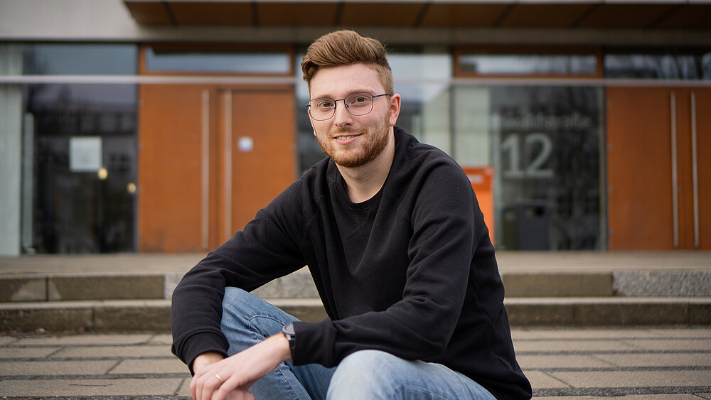 Johannes Krutz sits on the landing in front of the canteen.