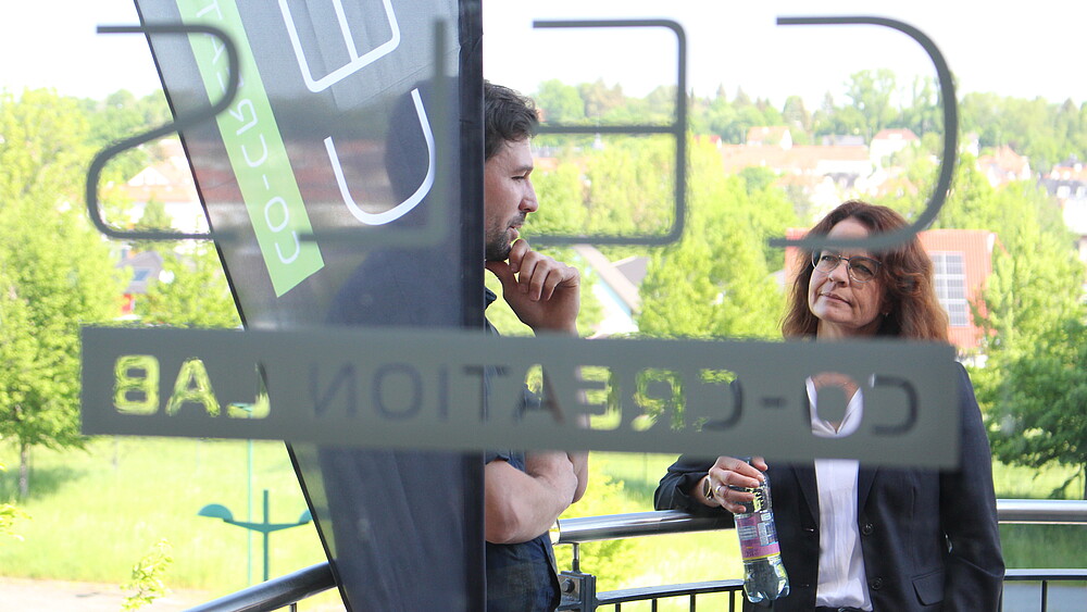 Two participants of the "Leading to success" training course in discussion on the outside landing of the Celsiuz co-creation lab.