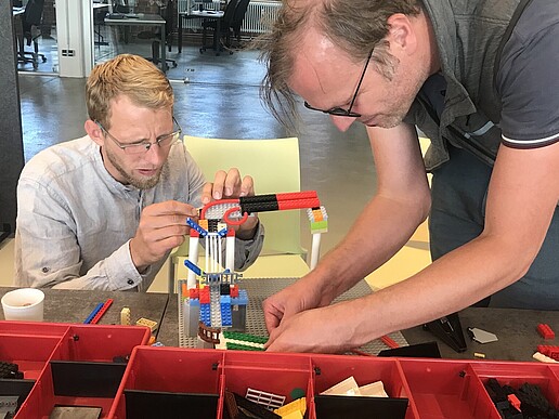 Two HSZG employees tinker with a Lego marble run in Celsiuz.