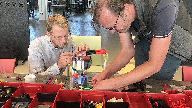 Zwei HSZG-Mitarbeitende basteln an einer Lego-Murmelbahn im Celsiuz.