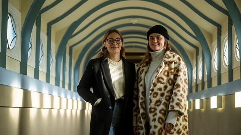 Zwei Studentinnen stehen im Görlitzer Hochschulgebäude in Winterkleidung.