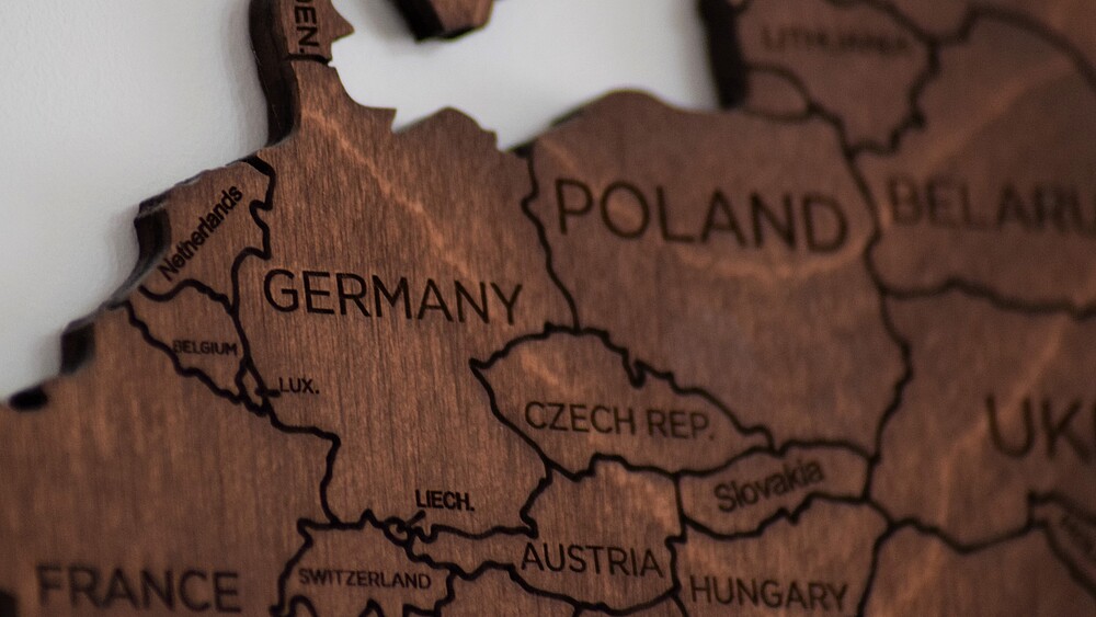 A wooden map of Europe on which you can clearly see the countries of Germany, Poland and the Czech Republic.