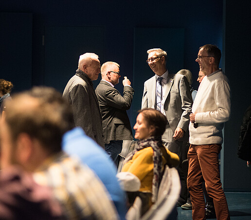 A group of men are talking.