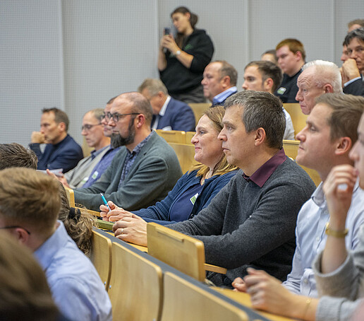 The rows of seats are filled with people looking ahead.