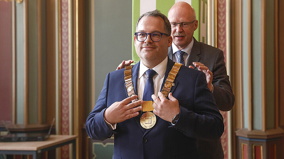 Prof. Drossel hangs the chain of office on Prof. Kratzsch in the Bürgersaal.