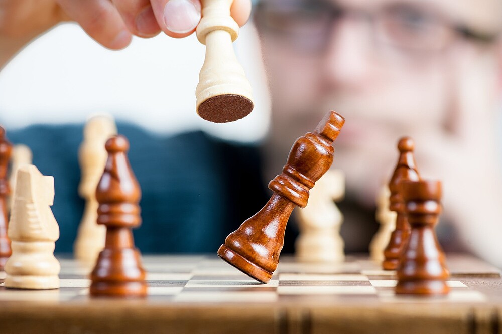 Person holds chess figure