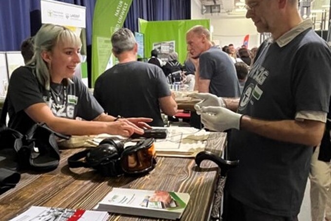 An employee advises a visitor at the GAT stand.