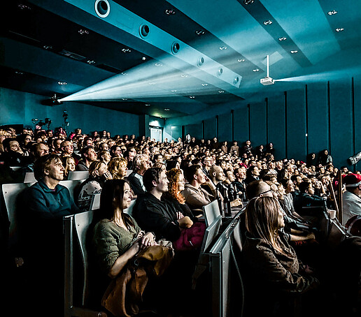 The audience looks towards the stage.