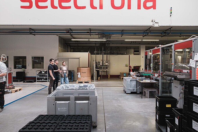 Large Selectrona logo on the wall in a factory building.