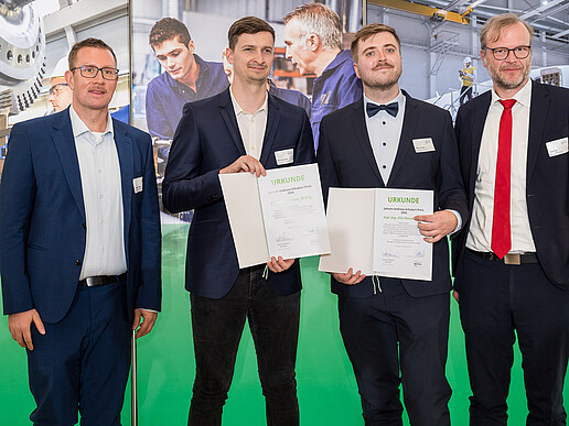 Christian Vogel, Manuel Isensee, Marcel Kupke und Daniel Fiß stehen bei der Preisverleihung nebeneinander; Manuel Isensee und Marcel Kupke halten ihre Urkunden in den Händen.