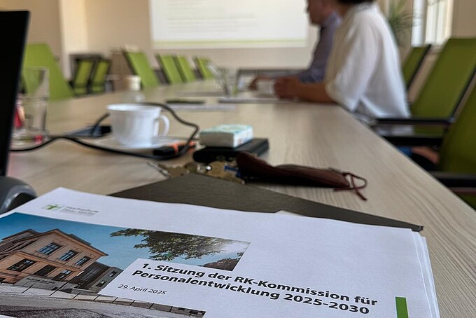 A printed paper with the cover sheet for a presentation on the subject of the Personnel Development Commission is lying on a conference table.