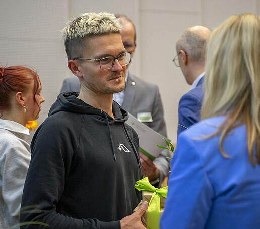 An award winner holds a gift in his hands.