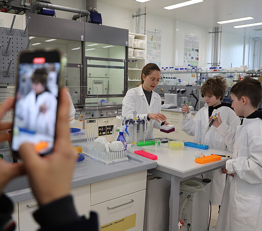 Two students at the pipetting station in the laboratory working with pipettes.