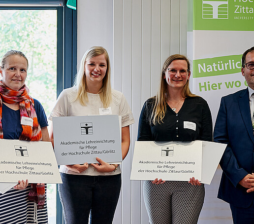 Rector with three cooperation partners in the care sector. They are holding their figurehead and certificate in their hands.