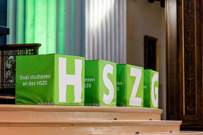 Four green cubes bearing the white letters H, S, Z, and G stand on the steps in the sanctuary of St. John's Church.