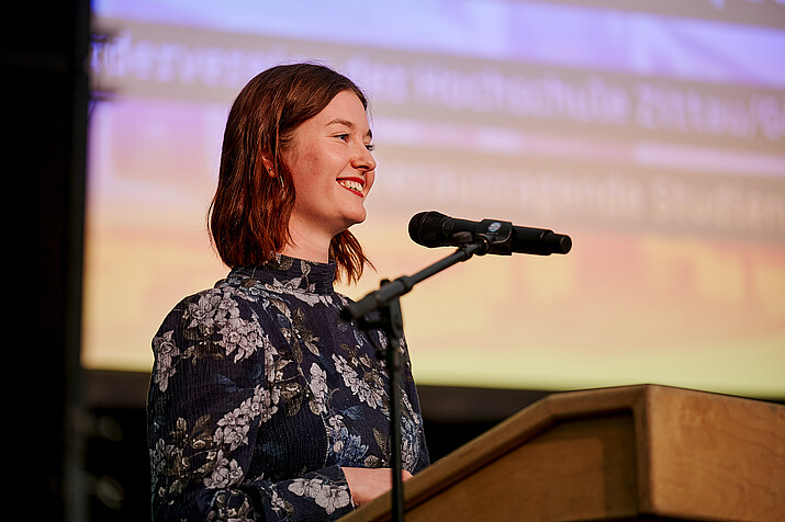 Alexandra Lucia Klein at the microphone on stage.