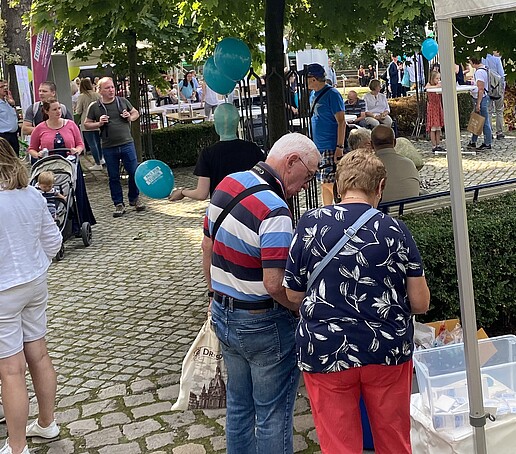 Im Außenbereich des SMWK versammeln sich viele Besuchende.