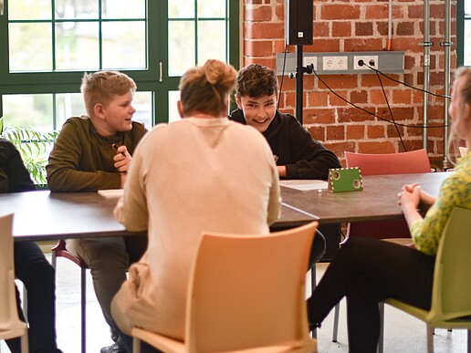 The organization team of the Science Cinema in the Village sits around a table in Celsiuz and discusses.