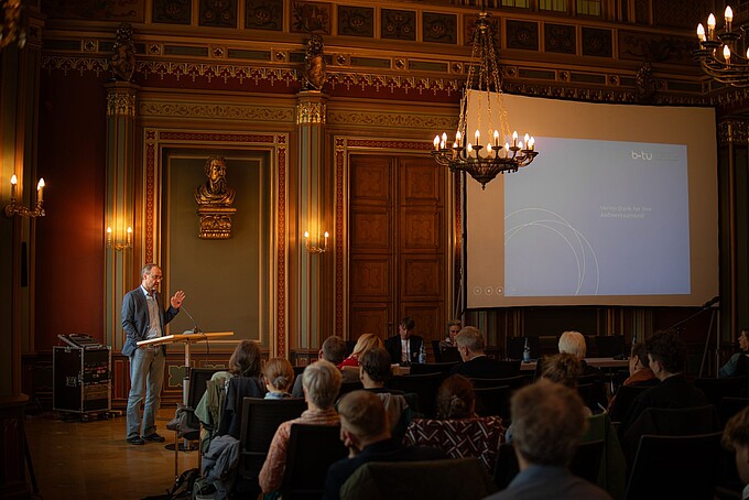 Prof. Kollmorgen speaks to the audience at the lectern.
