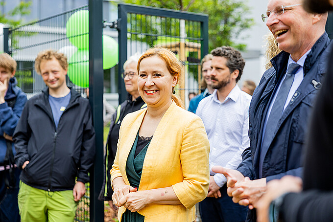 Gäste der Veranstaltung lachen und unterhalten sich.