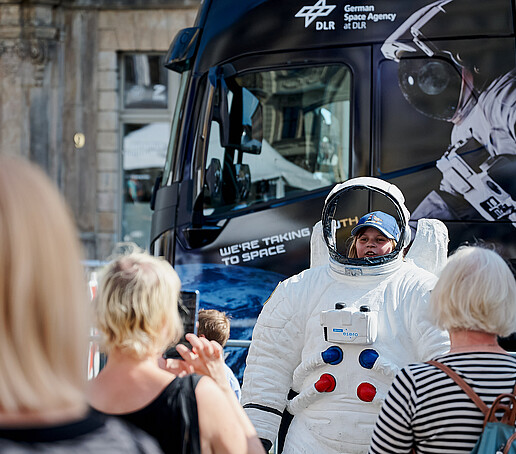 Children pose with a spacesuit.