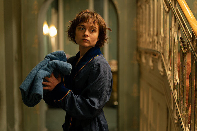 A performer from Franky Five Star in a bathrobe and towel