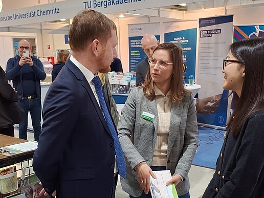 Der Sächsische Ministerpräsident im Gespräch mit der Studienberaterin und Zhaniya am HSZG-Stand.