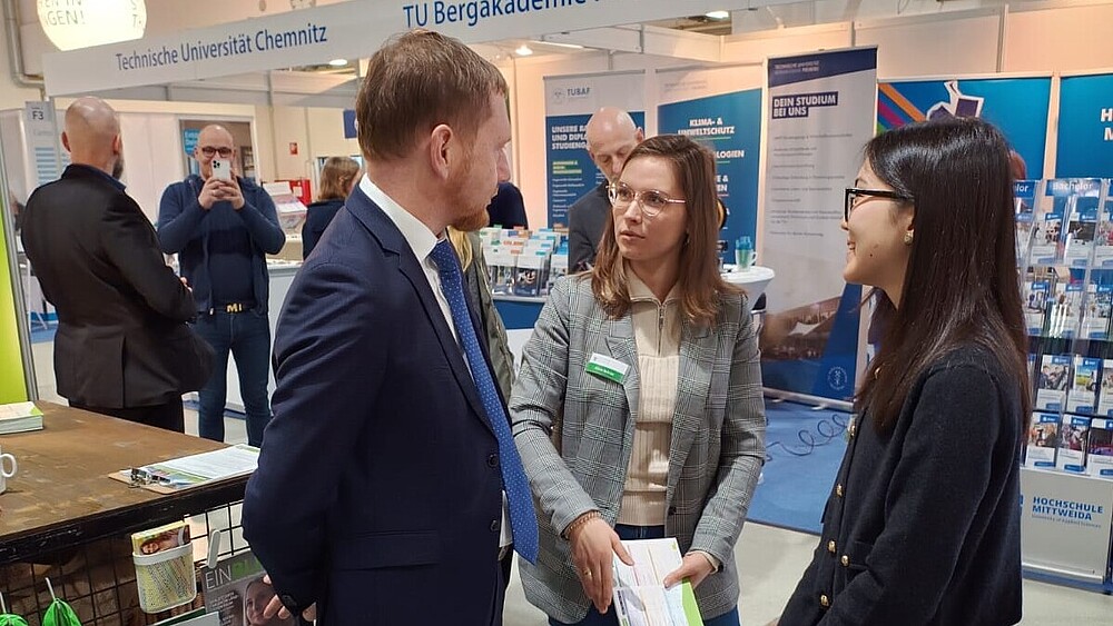 Der Sächsische Ministerpräsident im Gespräch mit der Studienberaterin und Zhaniya am HSZG-Stand.