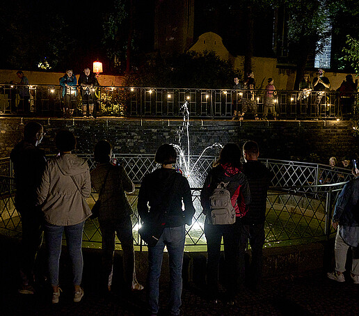 Visitors stand at the Schleifermännchen fountain.