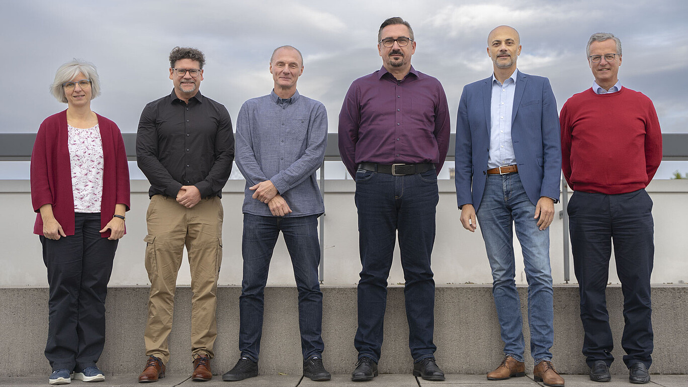 The dean and the deans stand for a group photo on the roof terrace of building Z four.