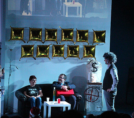 Two actors talk to Mrs. Hollstein and the principal.