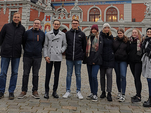 Prof. Jörg Kroschel with his students in front of a building in the center of Riga.