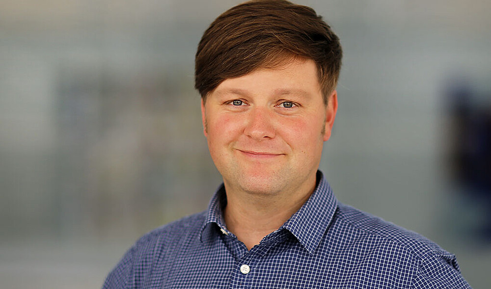 Daniel Winkler lächelt in die Kamera.