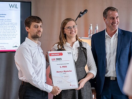 At the LEX award ceremony, the runners-up hold their certificates up to the camera.