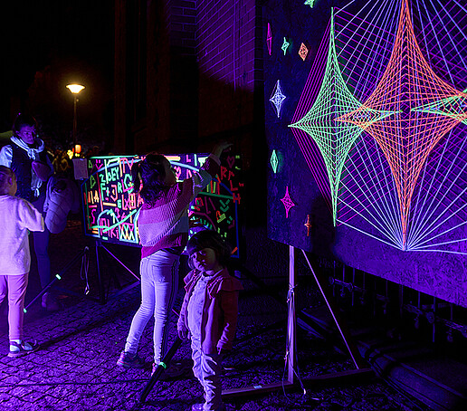 Children paint with neon colors on a canvas.