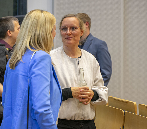The Vice President is talking to a woman wearing a white jacket.